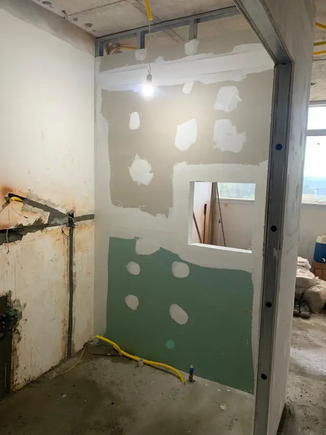 Montante metálico e placa verde de drywall em divisão interna da clínica